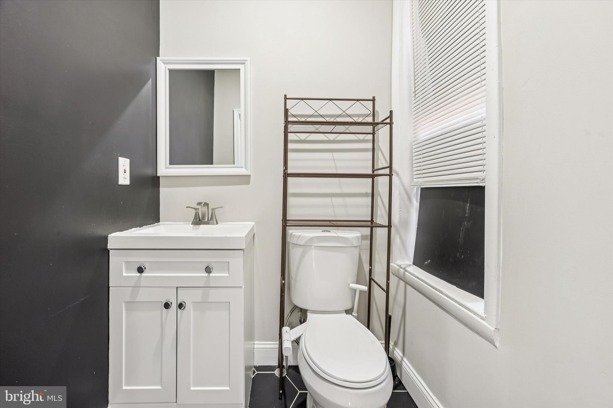 2336 Pierce Street Philadelphia, PA 19145 - Photo 5 of 18 a bathroom with a toilet sink vanity and mirror