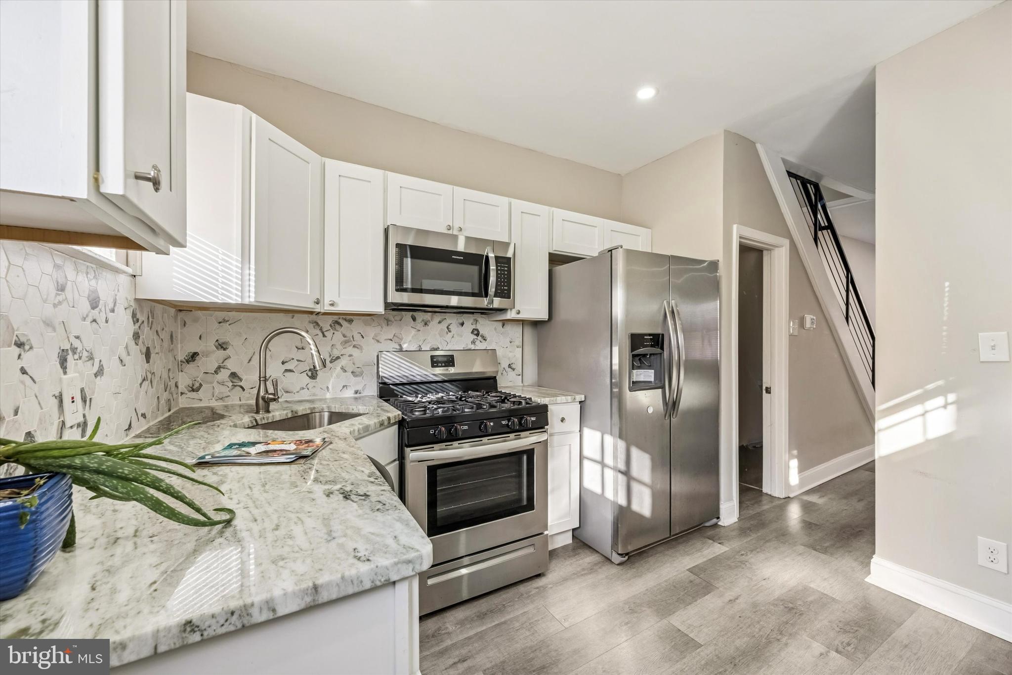 2336 Pierce Street Philadelphia, PA 19145 - Photo 6 of 18 a kitchen with kitchen island a stove a sink and a refrigerator