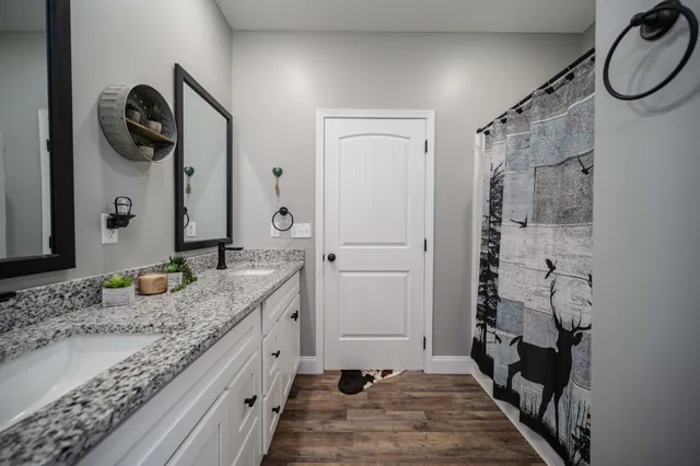 a bathroom with a granite countertop sink and a mirror