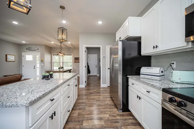 a large kitchen with kitchen island a sink stainless steel appliances and cabinets