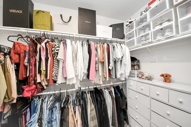 a view of walk in closet with clothes and shoes