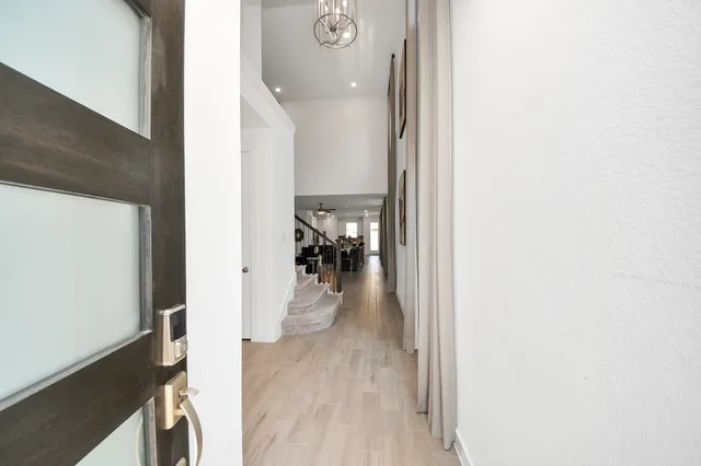 a view of a hallway with wooden floor and a living room