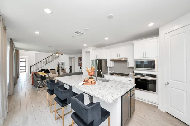 a open kitchen with stainless steel appliances granite countertop a stove refrigerator and a stove top oven