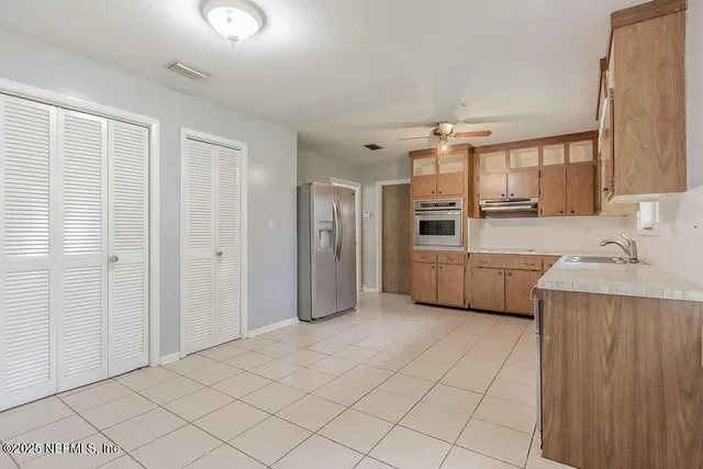 a kitchen with stainless steel appliances a sink and a refrigerator