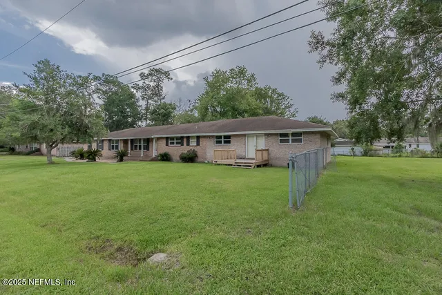 a view of a house with a backyard