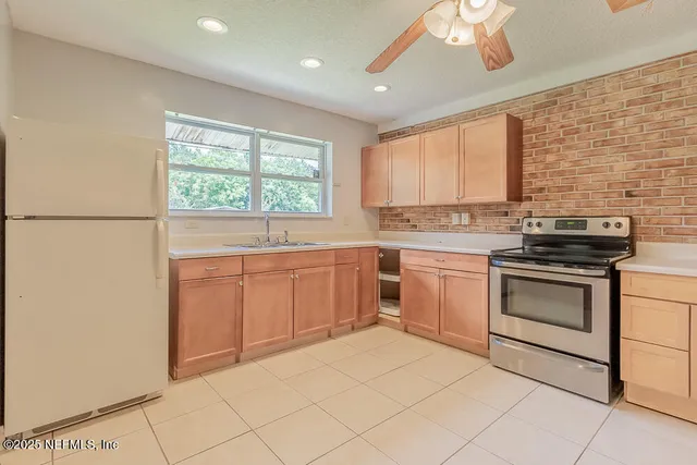 a kitchen with a stove a sink and a window