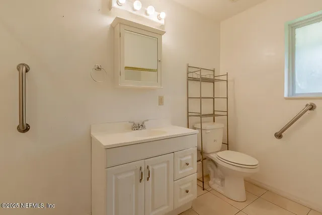a bathroom with a toilet sink vanity and mirror