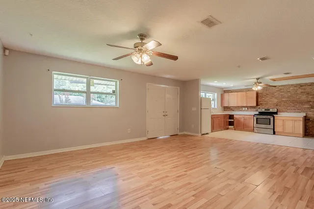 a view of a kitchen with microwave and wooden floor