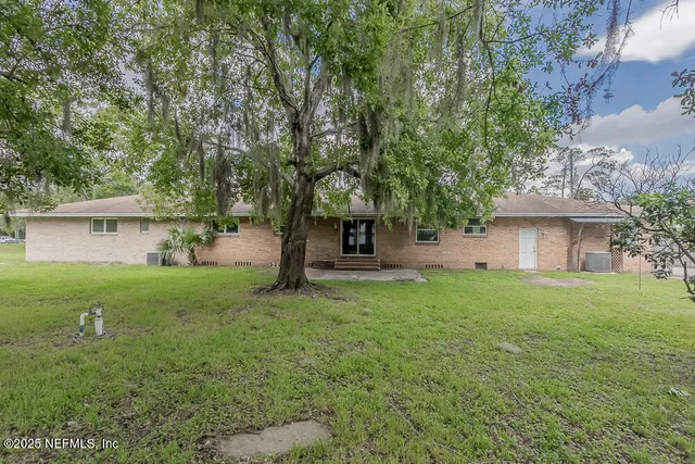 a view of a house with yard and a tree