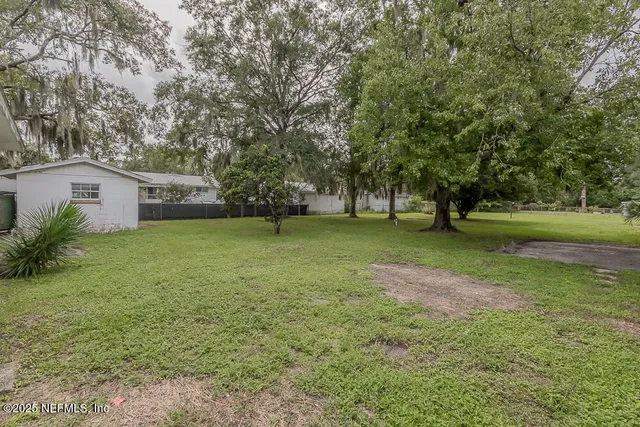 a view of a green field with trees