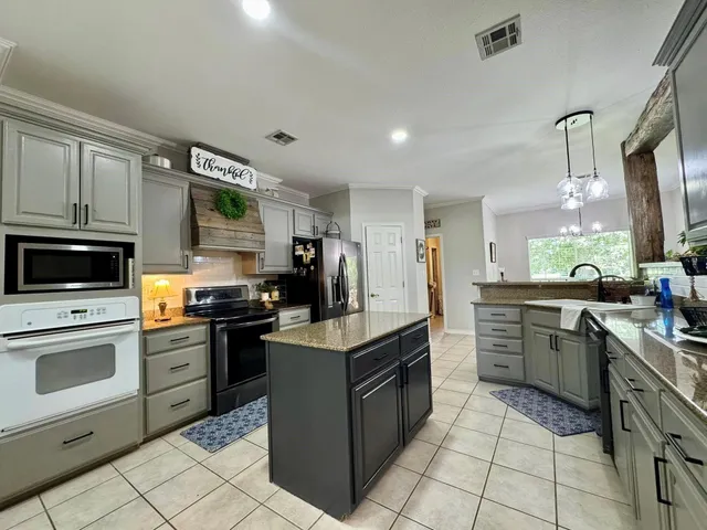 a kitchen with stainless steel appliances granite countertop a refrigerator and a stove top oven