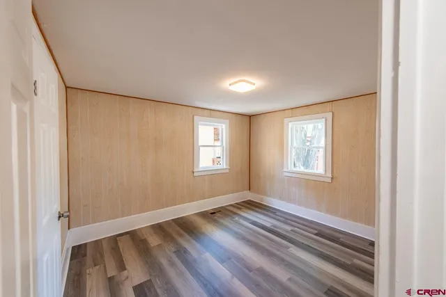 a view of room with wooden floor and windows