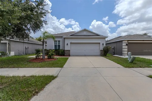 a front view of a house with a yard and a garage