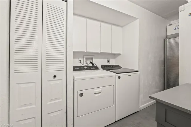a kitchen with a refrigerator and white cabinets