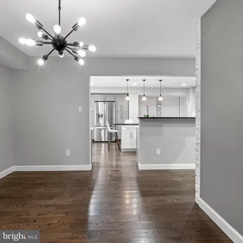 a view of a kitchen with wooden floor and a ceiling fan