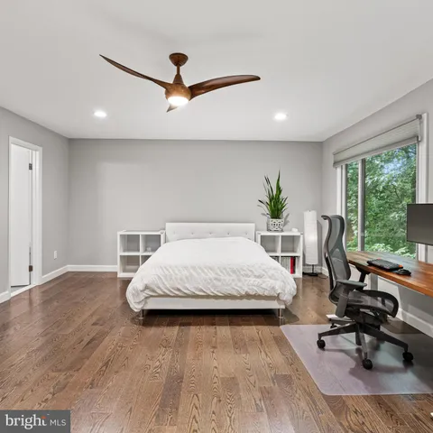 a spacious bedroom with a bed and a ceiling fan