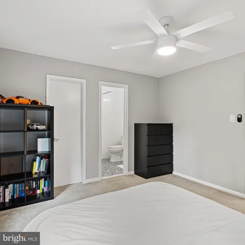 a white toilet sitting next to a white sink and vanity
