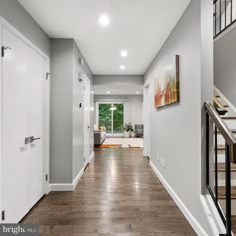 a view of a hallway with wooden floor and livingroom