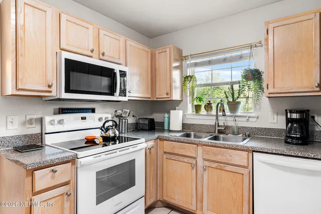 a kitchen with stainless steel appliances granite countertop a sink stove and microwave