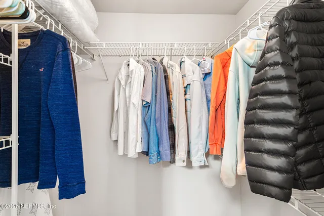 a view of walk in closet with clothes