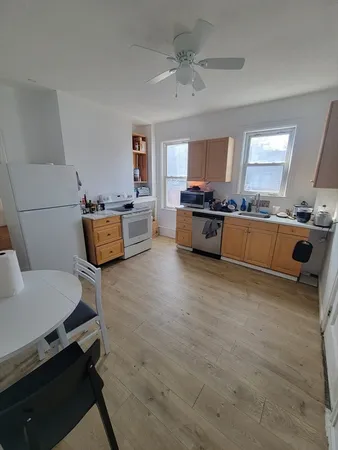 a large white kitchen with a stove a sink dishwasher and a stove with wooden floor