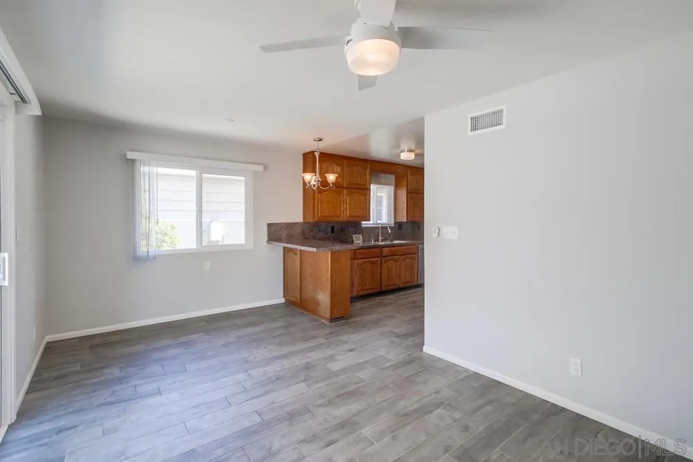 7568 Ohio Place La Mesa, CA 91942 - Photo 11 of 32 an empty room with a fireplace and wooden floor