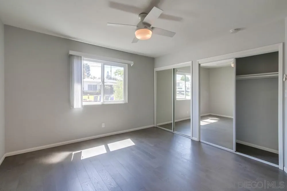 7568 Ohio Place La Mesa, CA 91942 - Photo 19 of 32 an empty room with wooden floor and windows