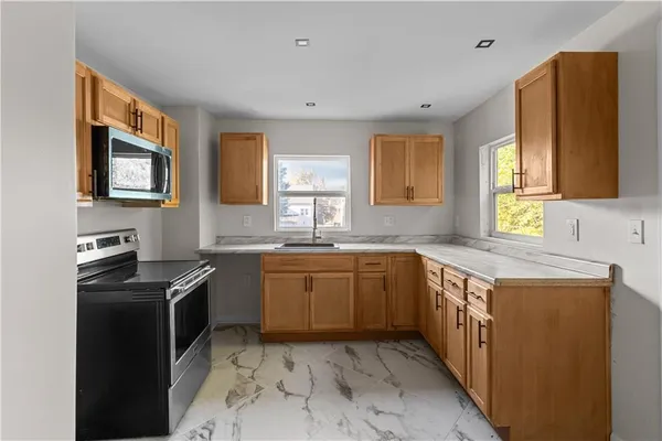 a kitchen with stainless steel appliances granite countertop a sink stove and microwave