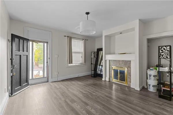 a view of an empty room with fireplace and a window