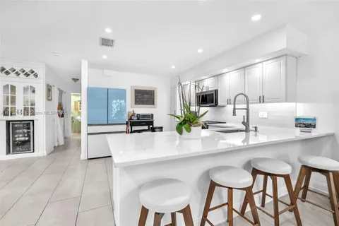 a kitchen with granite countertop a sink cabinets and stainless steel appliances