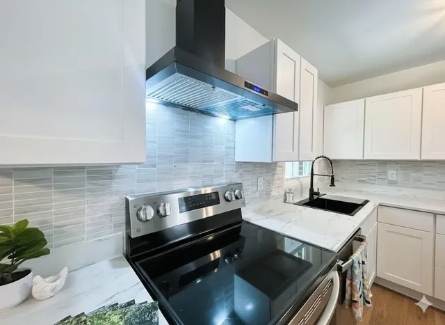 a kitchen with a sink a stove and cabinets