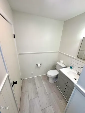 a bathroom with a toilet a sink and a mirror