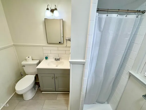a bathroom with a sink and mirror with toilet
