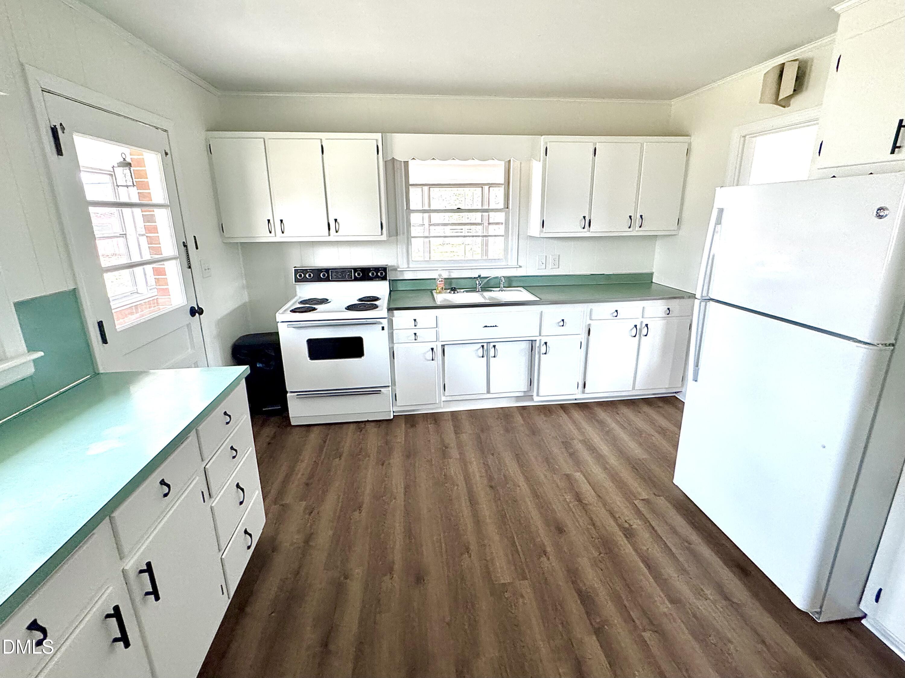 30 Nandina Drive Roxboro, NC 27573 - Photo 12 of 31 a kitchen with a sink a stove a refrigerator and white cabinets