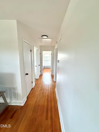 a view of a hallway with wooden floor