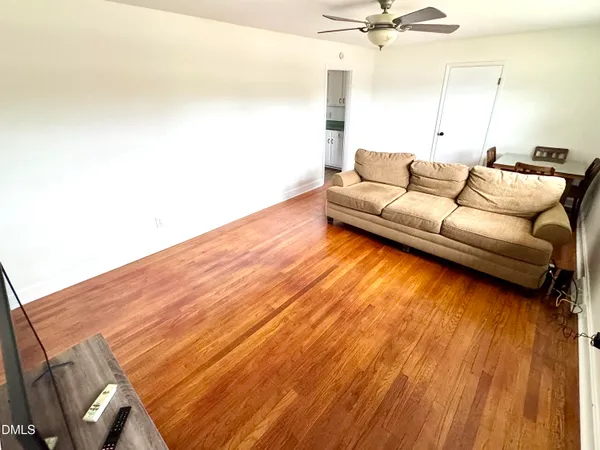 a living room with a bed furniture and a wooden floor