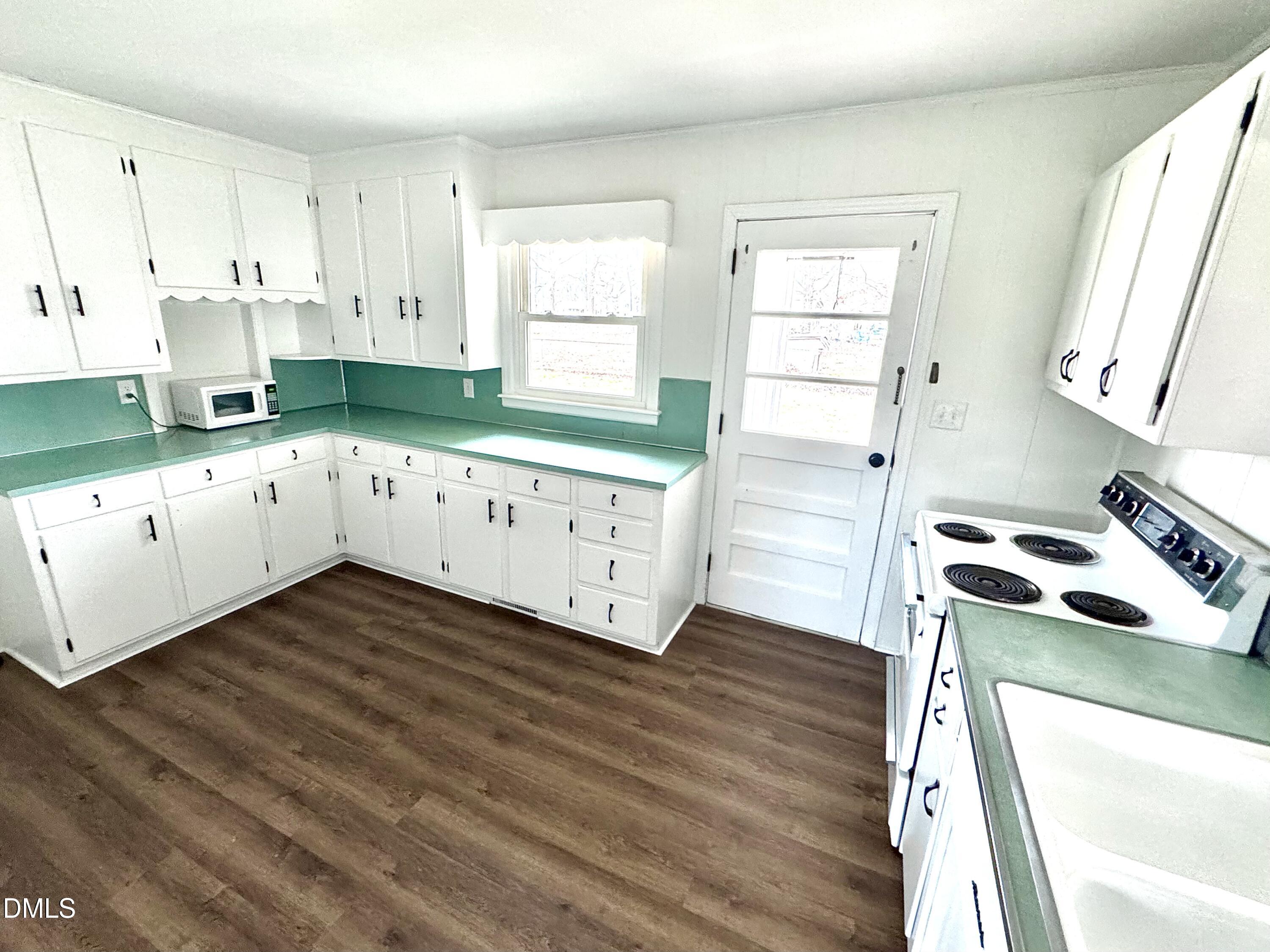 30 Nandina Drive Roxboro, NC 27573 - Photo 6 of 31 a kitchen with wooden floors and white appliances