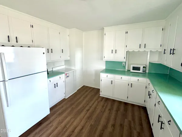 a kitchen with cabinets a refrigerator and a stove