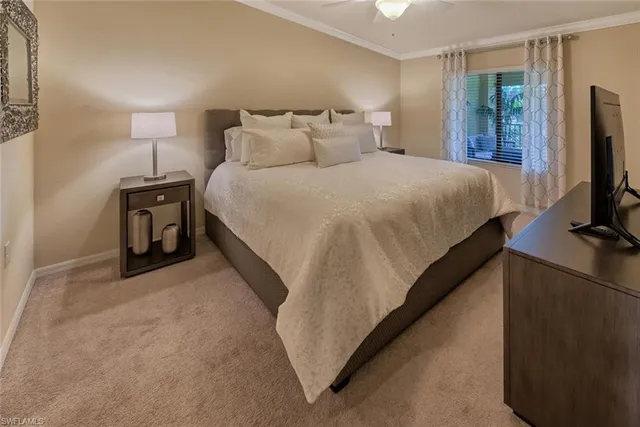 a bedroom with a bed and a flat tv screen on a dresser