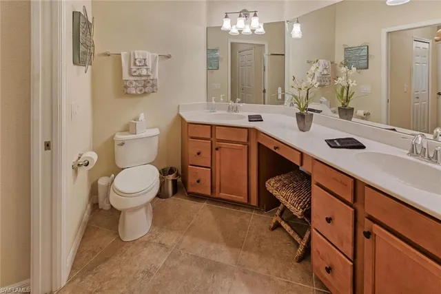 a spacious bathroom with a toilet a sink and a mirror