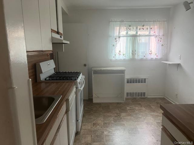 51-10 248th Street Queens, NY 11362 - Photo 6 of 8 a kitchen with a refrigerator and a stove top oven