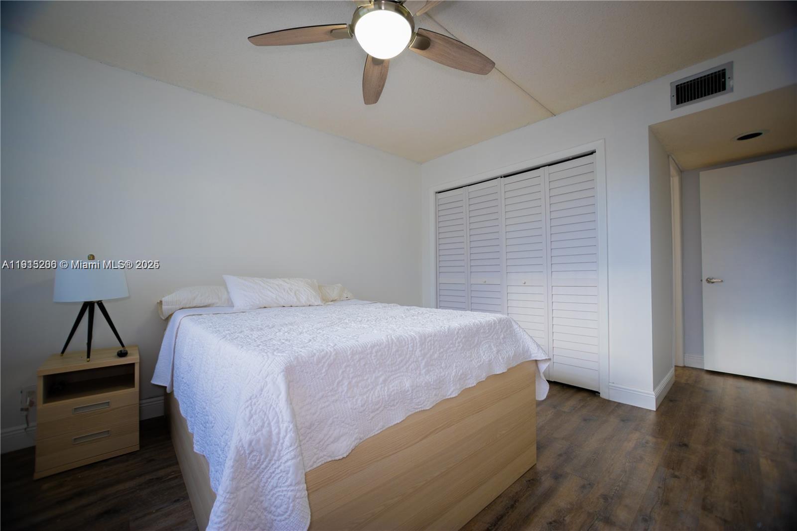 16100 Golf Club Road, Unit 202 Weston, FL 33326 - Photo 17 of 31 a bedroom with a bed and wooden floor