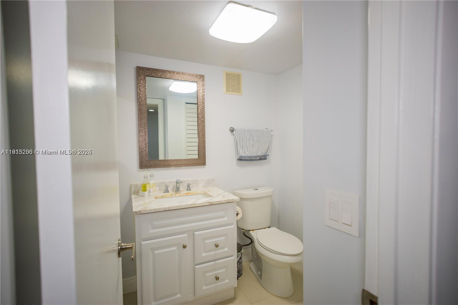 16100 Golf Club Road, Unit 202 Weston, FL 33326 - Photo 22 of 31 a bathroom with a granite countertop toilet sink and mirror