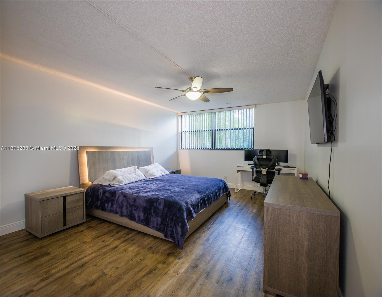 16100 Golf Club Road, Unit 202 Weston, FL 33326 - Photo 24 of 31 a spacious bedroom with a bed and a flat screen tv
