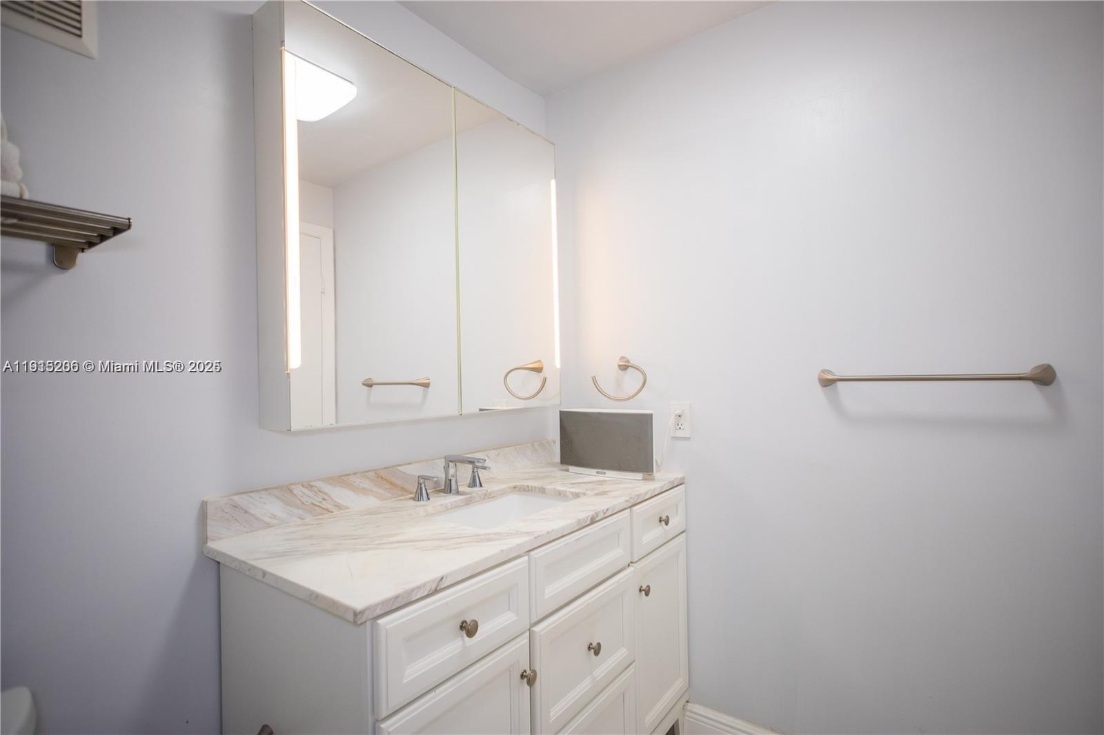 16100 Golf Club Road, Unit 202 Weston, FL 33326 - Photo 29 of 31 a bathroom with a sink vanity and a mirror