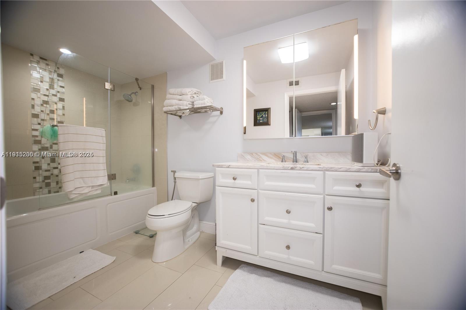 16100 Golf Club Road, Unit 202 Weston, FL 33326 - Photo 30 of 31 a bathroom with a granite countertop toilet sink and a mirror