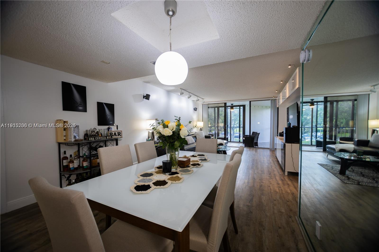 16100 Golf Club Road, Unit 202 Weston, FL 33326 - Photo 3 of 31 a view of a dining room with furniture and wooden floor
