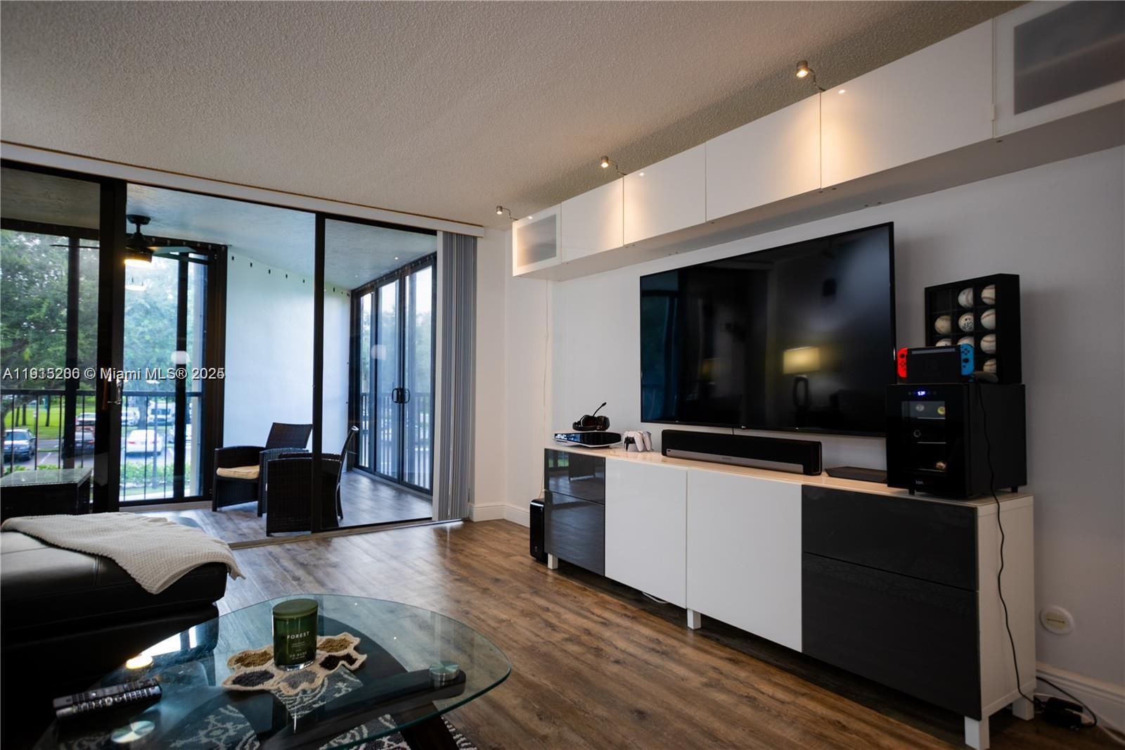 16100 Golf Club Road, Unit 202 Weston, FL 33326 - Photo 10 of 31 a living room with furniture and a flat screen tv