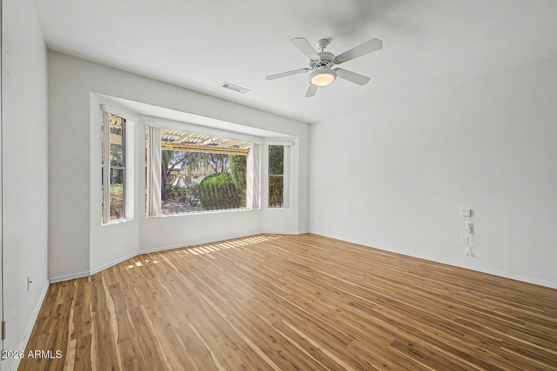 16731 West Oracle Rim Drive Surprise, AZ 85387 - Photo 11 of 54 a view of an empty room with wooden floor and a window