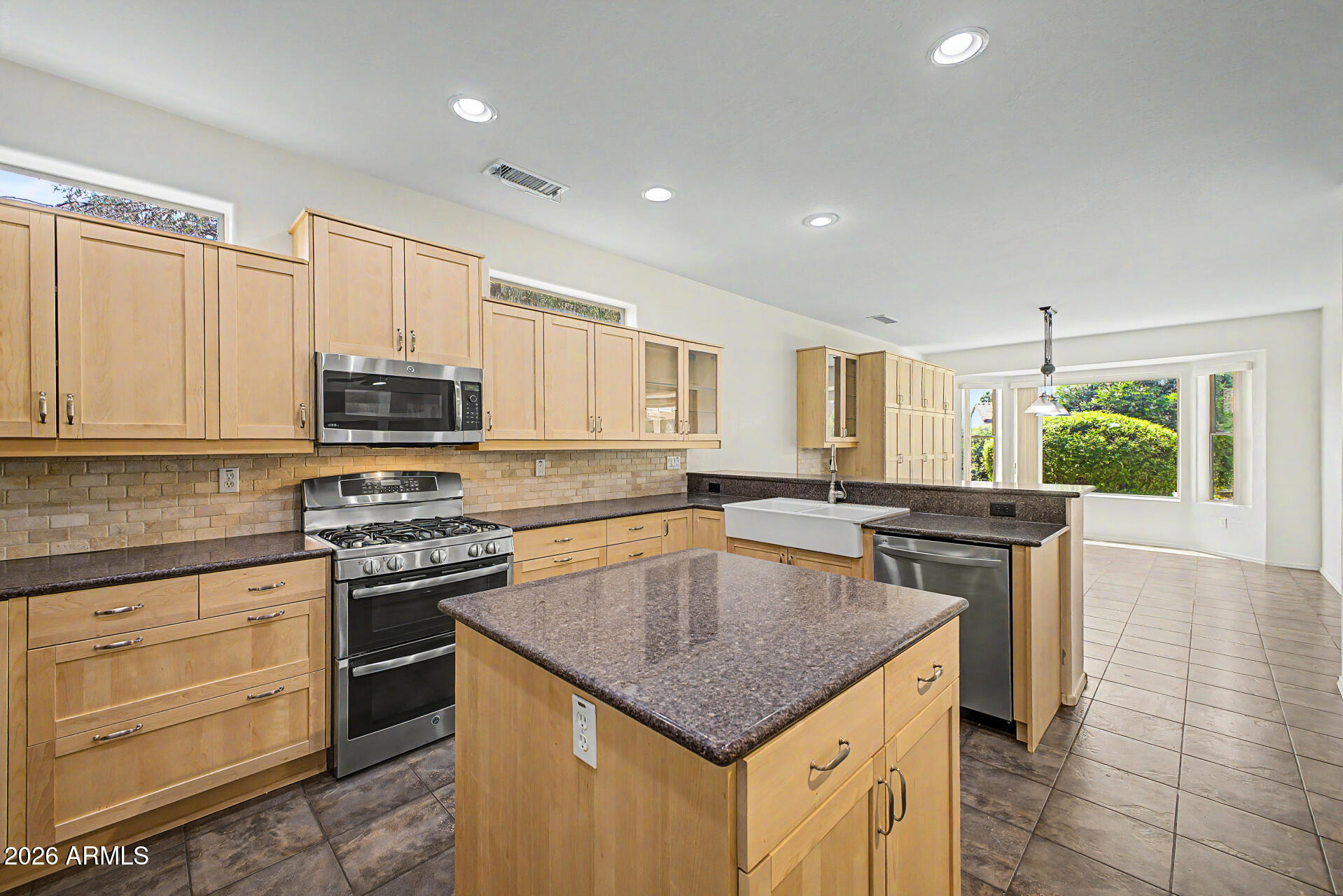 16731 West Oracle Rim Drive Surprise, AZ 85387 - Photo 20 of 54 a kitchen with stainless steel appliances granite countertop a stove a sink and a microwave
